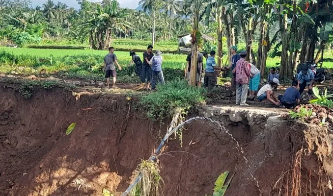 Puluhan warga dari dua desa di Pandeglang saat membuat jalan darurat di sekitar tanah longsor. (Poskota/Samsul Fatoni)