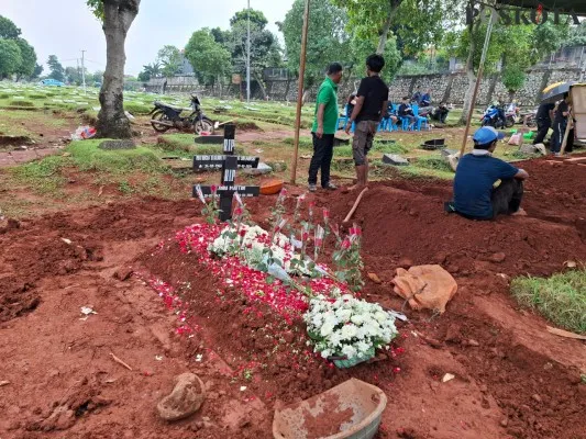 Makam ibu dan anak terpasang papan nisan salib bertuliskan nama terkubur dalam satu liang lahat di TPU Kampung Kandang, Jagakarsa, Jakarta Selatan. (Poskota/Angga)