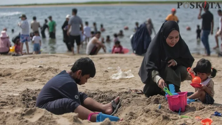 Sejumlah pengunjung berwisata saat libur lebaran di Pantai Lagoon, Taman Impian Jaya Ancol, Pademangan, Jakarta Utara, Kamis (11/4/2024). Menurut data dari PT Pembangunan Jaya Ancol Tbk, pada hari kedua Idul Fitri 1445 Hijriah jumlah kunjungan wisatawan ke objek wisata itu mencapai 77 ribu orang hingga pukul 16.00 WIB. Poskota/Ahmad Tri Hawaari