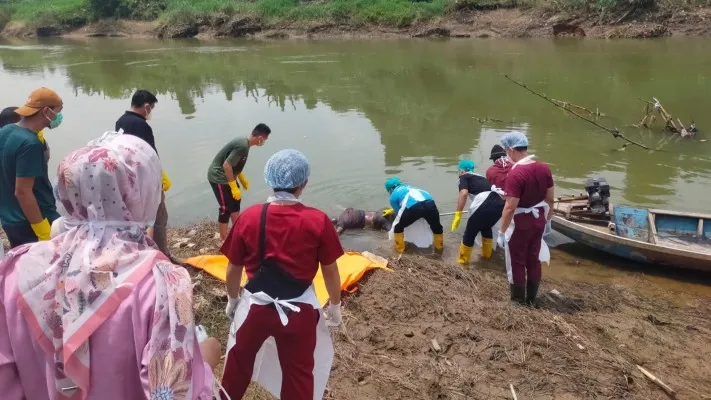 Tim medis RS Bhayangkara dibantu personel Polsek Kragilan saat mengevakuasi jasad pria gundul di Sungai Ciujung, Kabupaten Serang. (Dok. Polsek Kragilan)