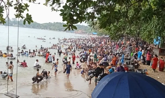 Para wisatawan saat melaksanakan liburan di Pantai Pasir Putih Carita Pandeglang. (Foto: Samsul Fatoni).