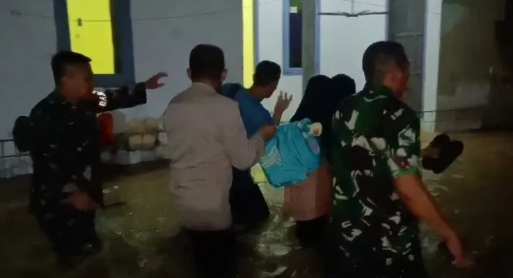 Kapolsek dan Danramil Kopo mengevakuasi korban dampak banjir di Kecamatan Kopo. (dok.polsek)