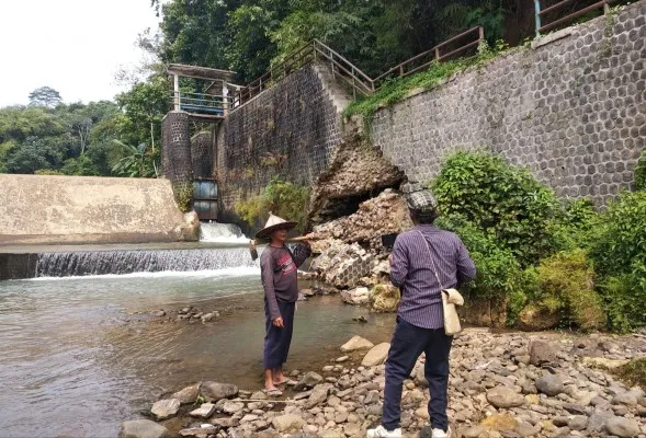 Salah seorang petani di Labuan Pandeglang saat menunjukkan tanggul yang jebol. (Dok. Warga)