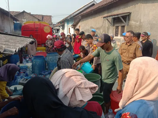 Suasana pembagian air bersih bantuan Polres Serang di Kampung Kesampangan Kabupaten Serang. (Poskota/Rahmat)