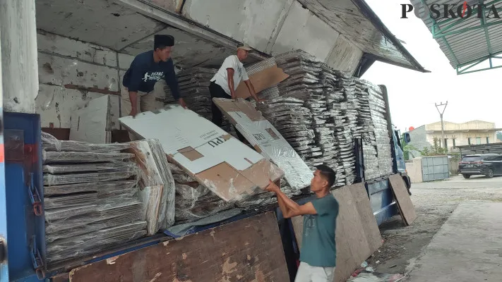 Sejumlah pekerja membongkar logistik di gudang KPU Pandeglang. (Poskota/Samsul Fatoni)