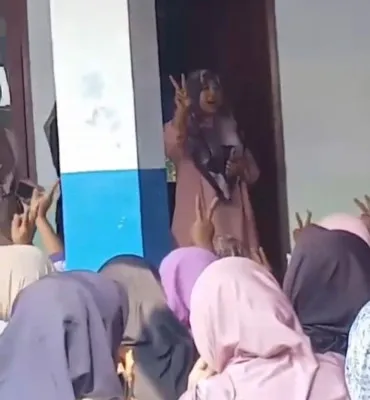 Puluhan warga saat menyampaikan yel-yel dukungan terhadap salah satu cabup Pandeglang dalam acara pembagian bansos beras di kantor Desa Cibodas Pandeglang. (Foto: tangkapan layar video)