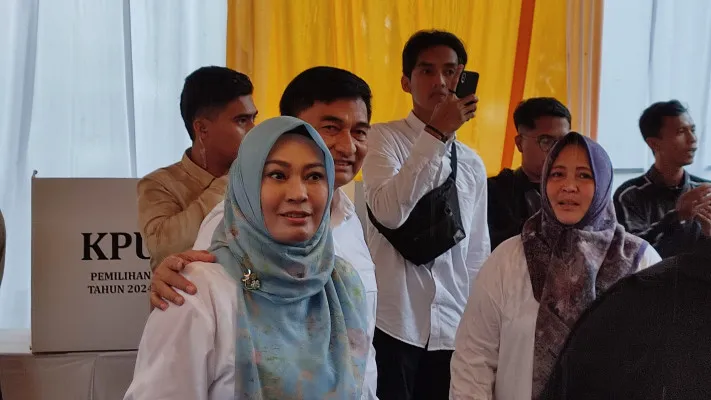 Cawagub Banten nomor urut 02, RD Ahmad Dimyati Natakusumah, mendampingi istrinya, Bupati Pandeglang Irna Narulita, mencoblos calon kepala daerah (Cakada) 2024 di TPS 12 Kelurahan Cigadung, Pandeglang, Rabu, 27 November 2024. (Poskota/Samsul Fatoni)