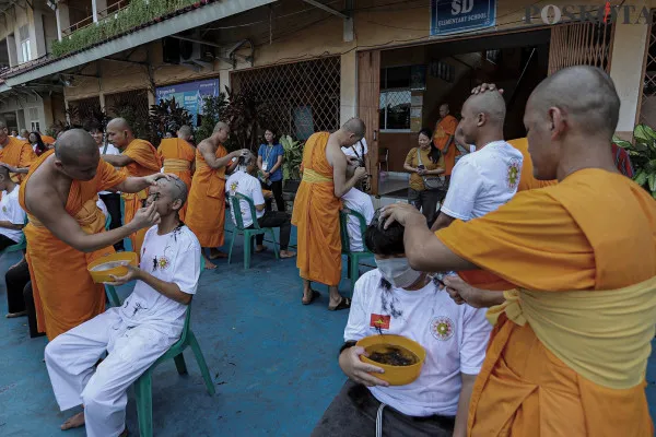 Bhikkhu mencukur rambut Samanera (calon Bikkhu) saat ritual cukur rambut dalam rangkaian Pabajja Samanera Sementara di Perguruan Buddhi, Kota Tangerang, Banten, Jumat, 20 Desember 2024. (Poskota/ Ahmad Tri Hawaari)