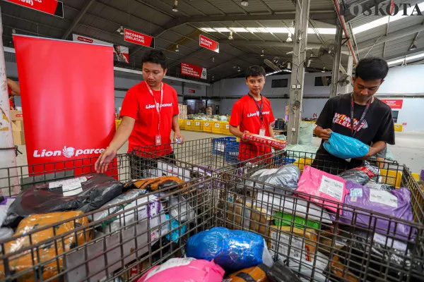 Petugas saat menyortir paket barang yang dibungkus menggunakan dus kemasanuntuk sebelum dikirim ke pelanggan di salah satu perusahaan pengiriman barang, Kota Tangerang, Banten, Minggu, 22 Desember 2024. (Poskota/ Ahmad Tri Hawaari)