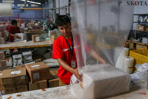 Petugas saat menyortir paket barang yang dibungkus menggunakan dus kemasanuntuk sebelum dikirim ke pelanggan di salah satu perusahaan pengiriman barang, Kota Tangerang, Banten, Minggu, 22 Desember 2024. (Poskota/ Ahmad Tri Hawaari)