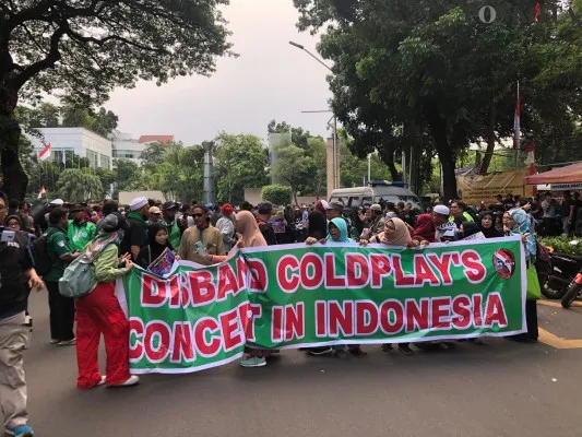 Belasan emak-emak sambil membawa spanduk bertuliskan 'Disband Coldplay's Concert In Indonesia' memaksa menerobos barisan polisi. (Pandi)