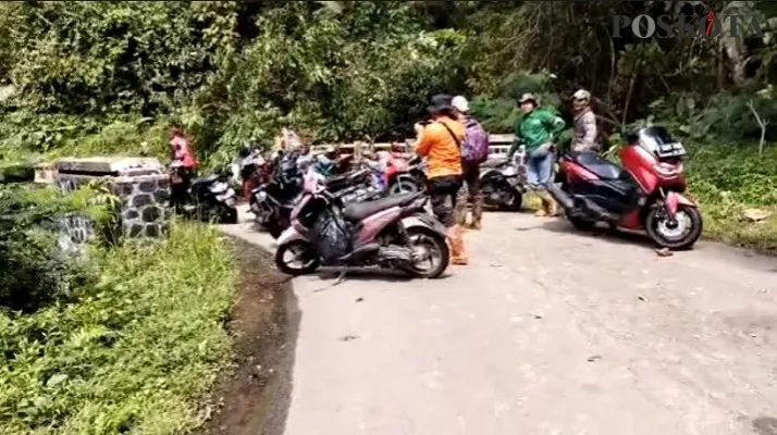 Sejumlah kendaraan milik warga yang terjebak material longsor di jalan Leuwiliang-Cianten hingga kini belum dievakuasi. (Foto: Billy)