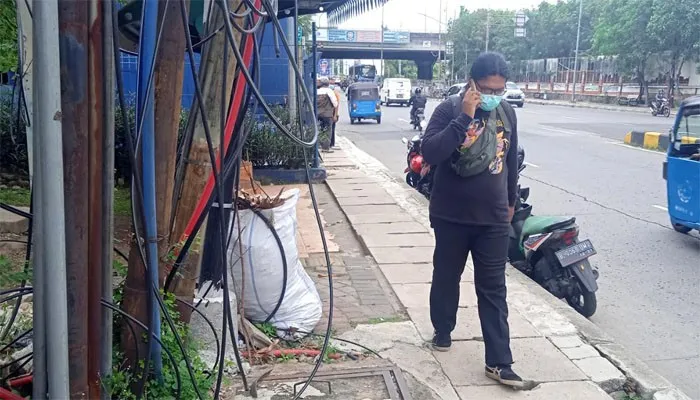 Kabel utilitas di Jalan Gunung Sahari Raya tepatnya di samping Rumah Pompa Viaduct tampak semrawut bahkan menjalar hingga ke trotoar. (yono)