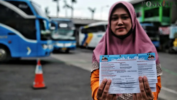 Foto: Peserta mudik gratis menunjukkan tiket keberangkatan untuk pulang kampung halaman. (Dok. Poskota)