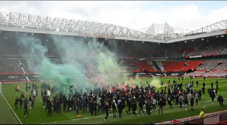 Ratusan fans Manchester United menyerbu lapangan Old Trafford.; (foto: AFP/the sun)