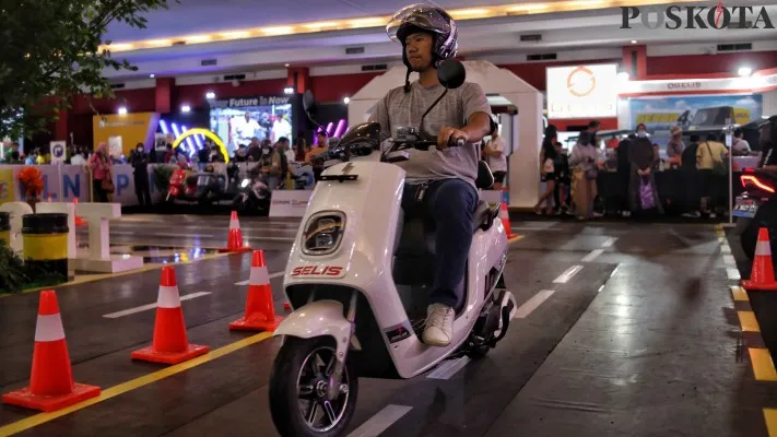 Seorang pengendara sedang melakukan test drive pada kendaraan roda dua bertenaga listrik.(Foto: Ahmad Hawaari)