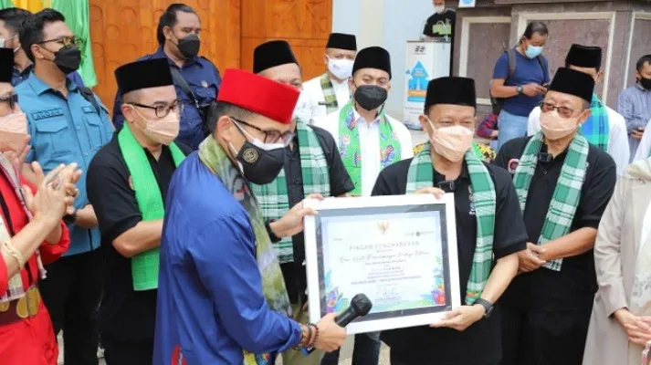 Kepada Plt Walikota Jaksel Isnawa Aji, Menteri Parekraf Sandiaga Uno berikan piagam PBB Setu Babakan masuk 50 besar Desa Wisata Terbaik ingkat nasional. (ist)