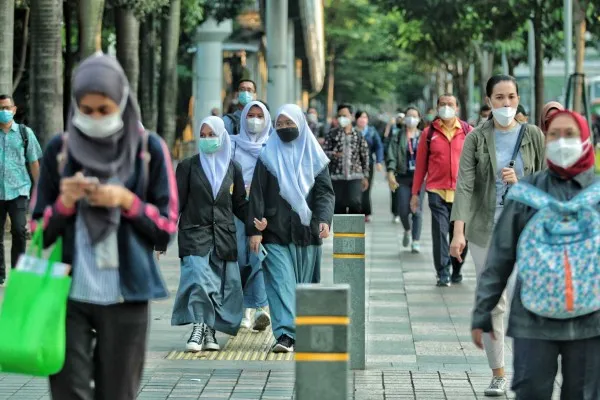 Sejumlah warga melintas di jalan kawasan Sudirman, Jakarta, Selasa (4/1/2022). Pemerintah Provinsi DKI Jakarta menetapkan untuk menaikkan status Pemberlakuan Pembatasan Kegiatan Masyarakat (PPKM) dari level satu menjadi level dua di DKI Jakarta mulai 4-17 Januari 2022. PosKota/Ahmad Tri Hawaari