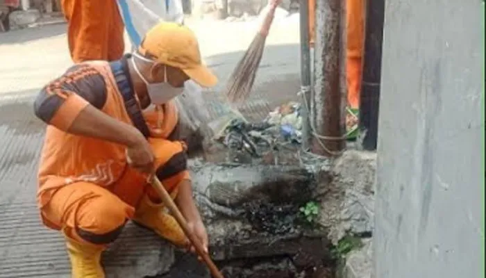 Petugas PPSU Kelurahan Pademangan Barat saat membersihkan saluran air di tiga RW. (Ist)