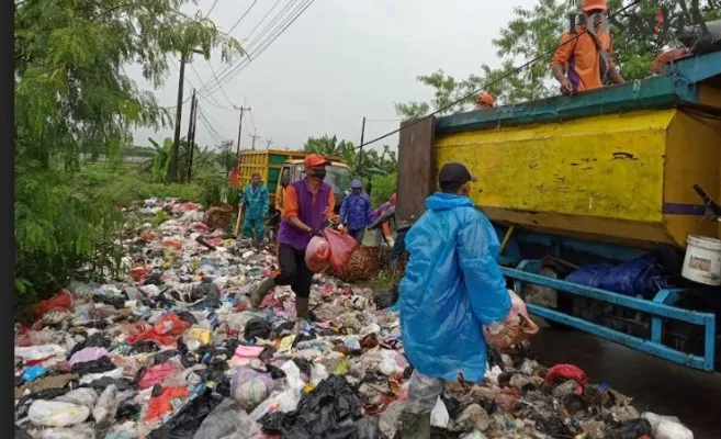 Petugas DLHK saat membersihkan tumpukan sampah. (Veronica)