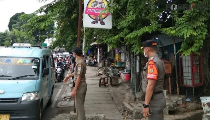 Petugas Satpol PP Kecamatan Palmerah yang sedang melakukan kegiatan tertib masker.(Cr04),