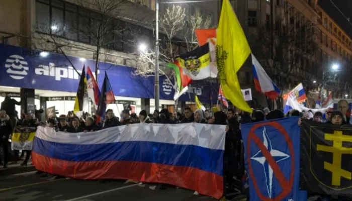 Demonstran sayap kanan Serbia membawa bendera Rusia dan mencoret bendera NATO dalam unjuk rasa di Beograd pada Jumat (4/3/2022).