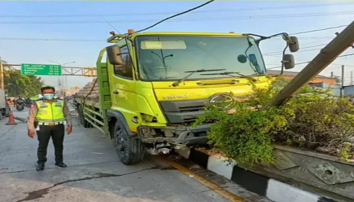 Petugas kepolisian saat mengevakuasi truk pengangkut semen yang menabrak pembatas jalan di Tambun Bekasi. (foto: ist)