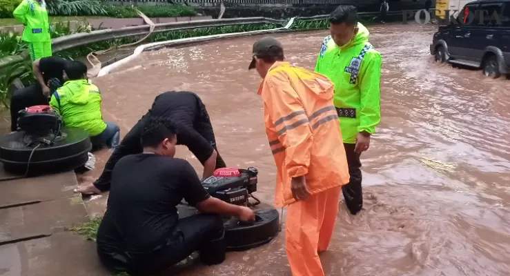 Petugas Sumber Daya Air Kota Bekasi mengerahkan pompa air untuk menyedot banjir di Jalan Ahmad Yani. (foto: ihsan)