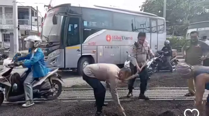 Polsek Cikarang Utara, Bejibaku lakukan penambalan jalan rusak di perlintasan kereta api. (Ist)