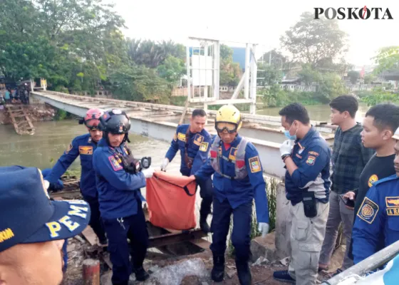 Foto: Petugas mengangkut jasad mayat tanpa identitaa ditemukan tewas hanyut di Kalimalang, Tambun, Bekasi. (Poskota/Ihsan Fahmi)