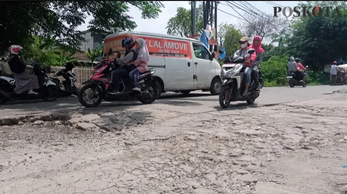 Pengendara sepeda motor menghindari jalan berlubang di Alinda, Bekasi Utara. (Ihsan Fahmi)