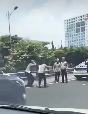 Dua anggota Polantas terlihat diberikan hukuman squat jump di pinggir jalan tol Dalam Kota. (Tangkapan Layar akun instagram @jakarta_info)