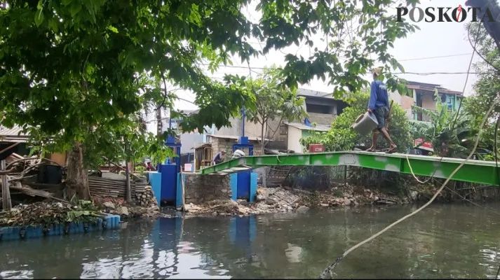 Warga RT 04 RW 5 Kelurahan Tugu Selatan, Cilincing, Jakarta Utara, urunan membuat jembatan besi sebagai pengganti jembatan kayu yang telah rapuh dan usang. (Poskota/Pandi)