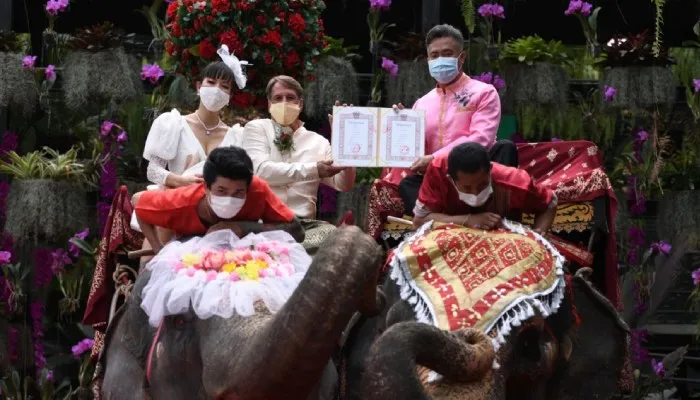 Pasangan suami istri menerima surat perkawinan dari petugas pada perayaan Hari Valentine di Taman Tropis Nong Nooch.