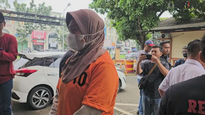 Tersangka penusukan seorang pedagang wanita di Tangerang hingga tewas menangis di Polsek Kelapa Dua. (Poskota/Veronica)