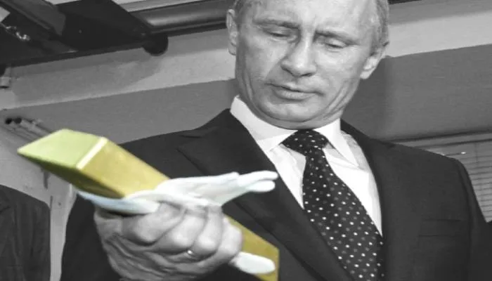 Vladimir Putin memegang emas batangan saat mengunjungi Bank Sentral Rusia di Moskow pada 24 Januari 2011.