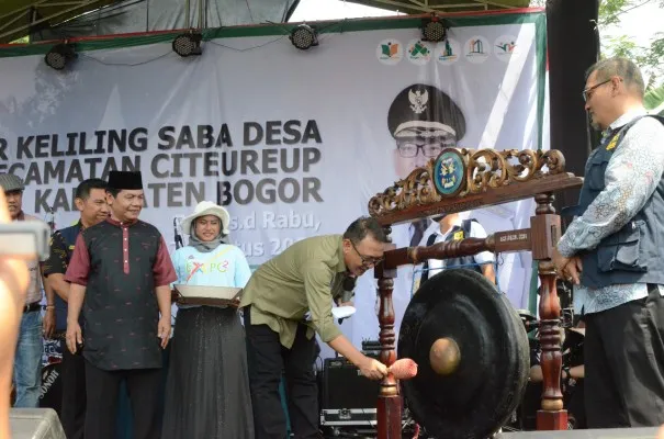 Foto : Plt. Bupati Bogor Iwan Setiawan memukul gong sekaligus aksi Gerakan 10 Juta Bendera yang diberikan secara simbolis kepada beberapa masyarakat dalam rangkaian menyambut Hari Kemerdekaan ke-77 RI, sekaligus membuka langsung kegiatan Tarikolot Expo yang berlangsung di lapangan Kenam Desa Tarikolot Kecamatan Citeureup. (Ist.)