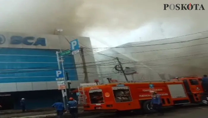 Karyawan Bank BCA dibantu warga tengah menyelamatkan dokumen dari dalam gedung. (haryono)