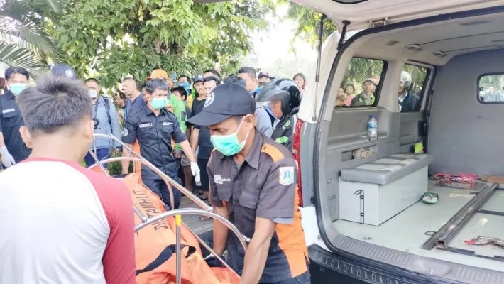 Petugas mengevakuasi mayat dengan leher terikat ditemukan di pinggir Kali Ciliwung, Jakpus. (Ist)