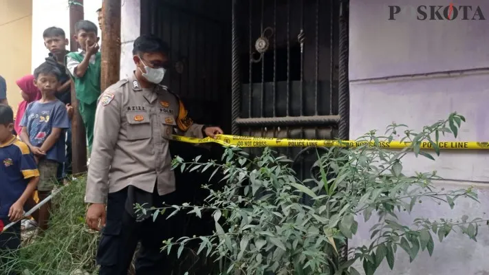 Polisi memasang garis polisi pada rumah di Kecamatan Ngamprah, Kabupaten Bandung Barat setelah ditemukan kerangka manusia. (Poskota/Gatot Poedji)