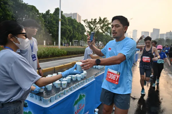 Foto: Artis Ibnu Jamil sedang mengambil minuman air mineral saat jadi Peserta Jakarta Running Festival 2024. (Dok. Panitia)