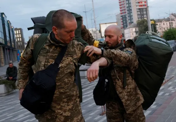 Pasangan LGBTQ, Anggota Pertahanan Teritorial Oleksandr Zhygan, 37,  dan rekannya Antonina Romanova, 37, bersiap untuk naik kereta ke garis depan, saat serangan Rusia ke Ukraina berlanjut, di stasiun kereta di Kyiv, Ukraina 25 Mei 2022. (Foto: Reuters)