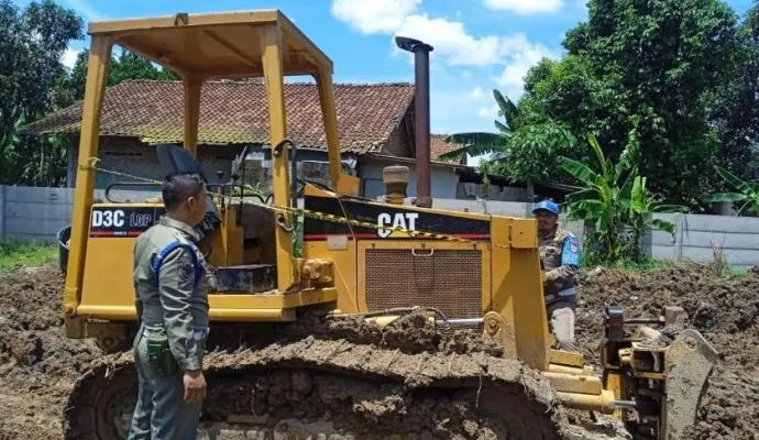 Petugas Satpol PP saat melakukan penyegelan slat berat. (Foto/Ist)