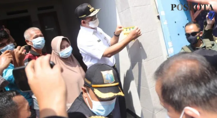 Gubernur DKI Jakarta, Anies Baswedan saat menempelkan stiker bebas Covid-19 di rumah pemudik yang telah kembali ke Ibukota di RW 05, Sunter Agung, Jakarta Utara. (yono)