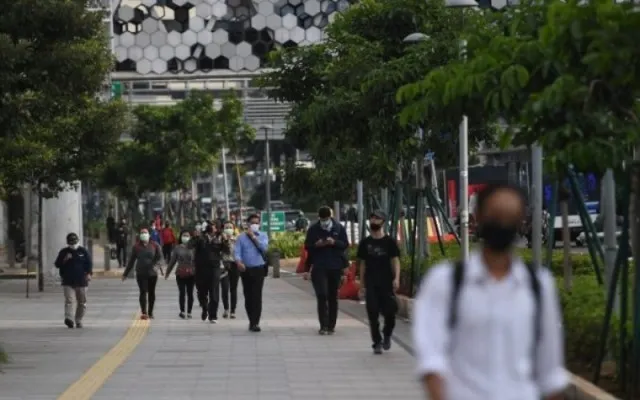 Ilustrasi: Sejumlah pekerja berjalan usai bekerja dengan latar belakang gedung perkantoran di Jl. Jenderal Sudirman, Jakarta, Kamis (16/4/2020). (Foto: Antara).