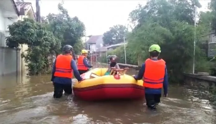 Akibat longsoran tebing menutup kali, banjir terjadi petugas damkar Kota Depok menurunkan perahu karet mengevakuasi warga. (Ist)