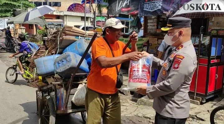 Kapolsek Sukmajaya Kompol Meltha Mubarak bagi-bagi bansos paket sembako ke warga.(angga)