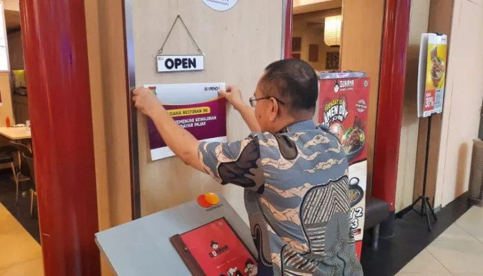 Penempelan stiker pada sebuah restoran penunggak pajak di Supermall Karawaci, Kota Tangerang. (Dok: Kominfo Kabupaten Tangerang)