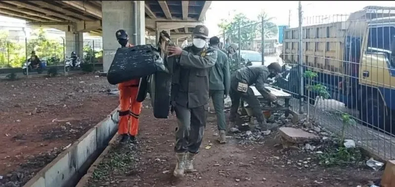 Petugas gabungan dari Kelurahan Cipinang Melayu tertibkan tempat penyimpanan barang bekas di kolong Tol Becakayu, Jalan Raya Inspeksi Kalimalang, RW 04, Makasar, Jakarta Timur.(Sudin Kominfotik Jakarta Timur)