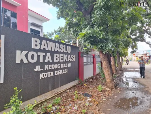 Warga saat melintas di halaman depan Kantor Bawaslu Kota Bekasi di Jalan Keong Mas III, Kayurungin, Bekasi Selatan, Kota Bekasi. (Poskota.co.id/Ihsan Fahmi)